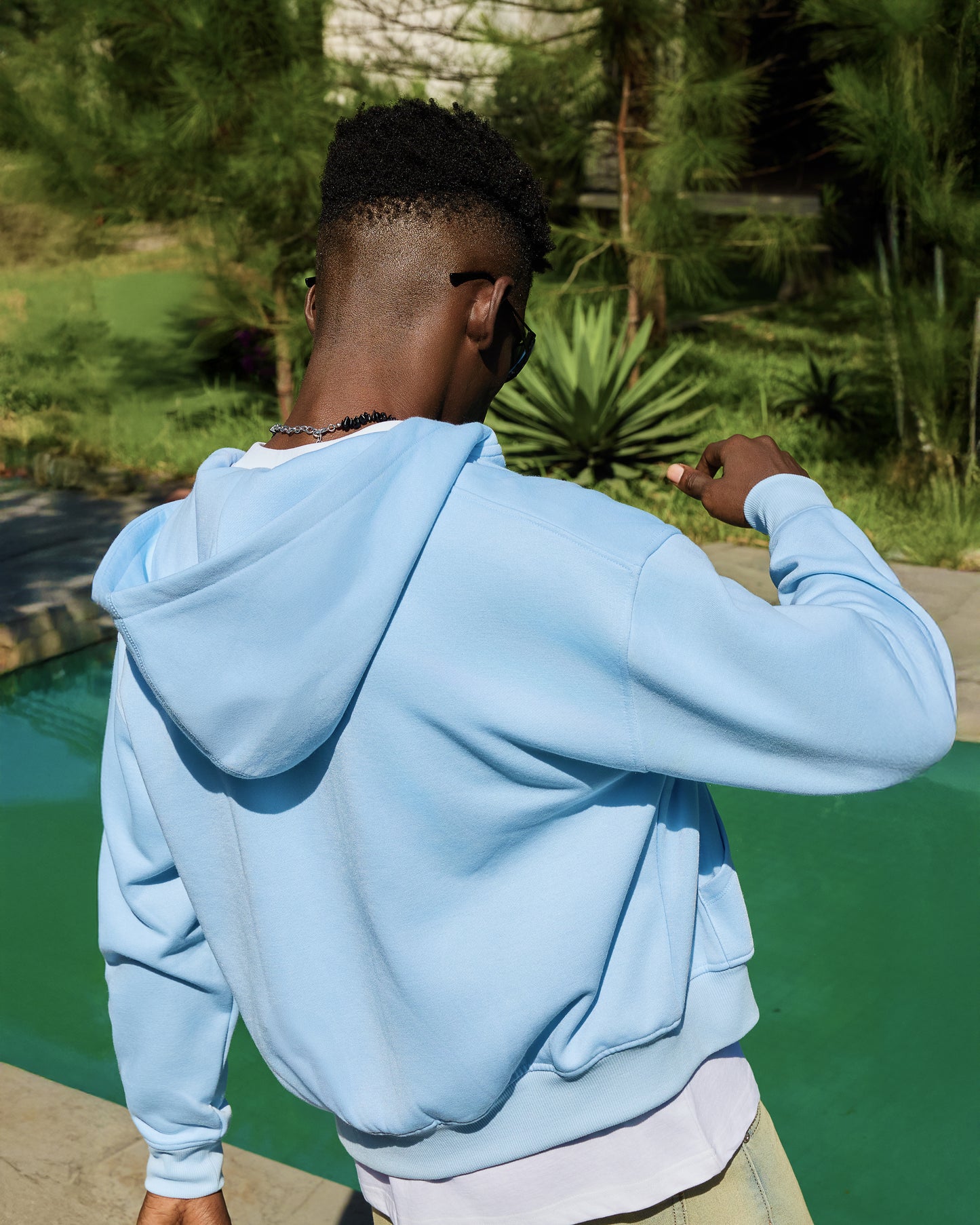 Back detail of the LAVIEM blue double-zip hoodie, featuring a minimalist streetwear design with dropped shoulders and ribbed hem.