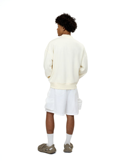 Back view of the LAVIEM beige oversized cotton sweater, showcasing its streetwear-inspired drop shoulders and layered casual menswear styling.